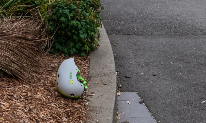 Casque de trottinette électrique posé près d’une chaussée