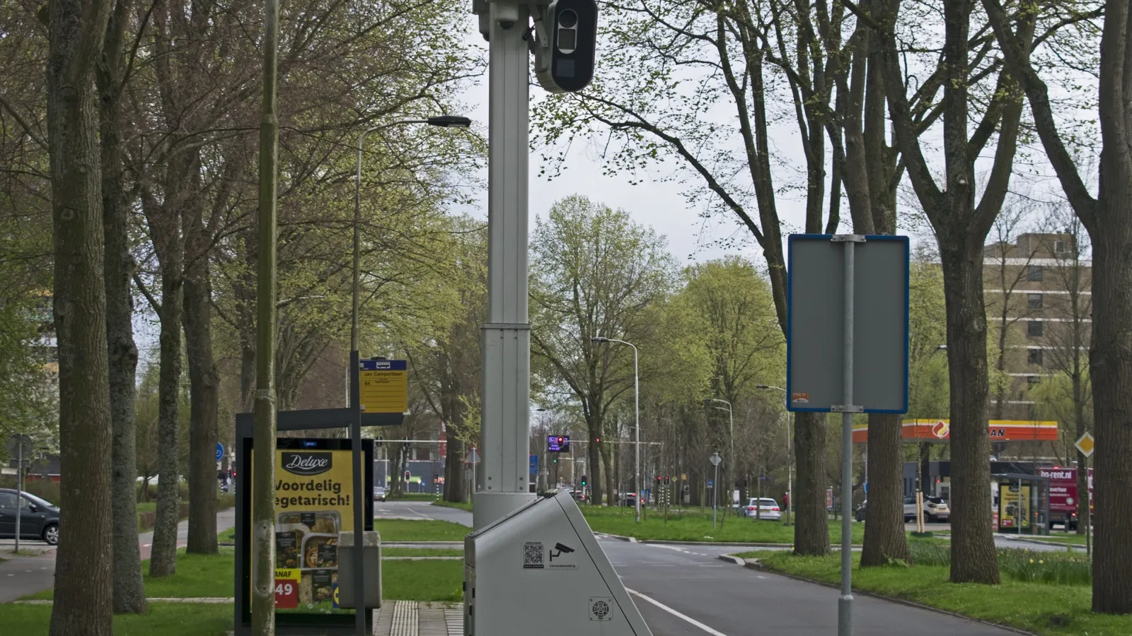 Radar fixe installé le long d’une route urbaine bordée d’arbres