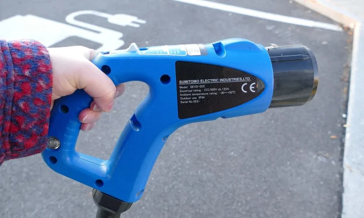 Voiture électrique réelle photographiée près d’une borne de recharge pour « Aides à l’installation d’infrastructures de recharge partagées en copropriété »