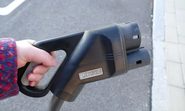 Voiture électrique réelle photographiée près d’une borne de recharge pour « L’amortissement des bornes de recharge pour les particuliers en Belgique »