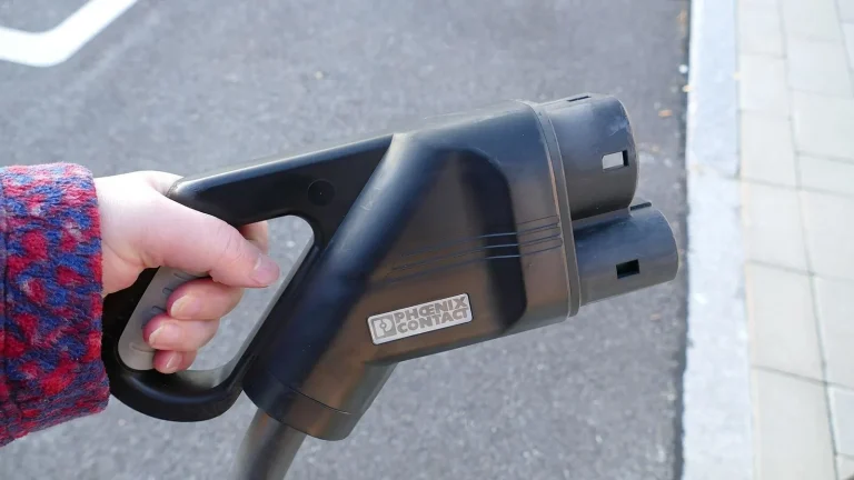 Voiture électrique réelle photographiée près d’une borne de recharge pour « L’amortissement des bornes de recharge pour les particuliers en Belgique »