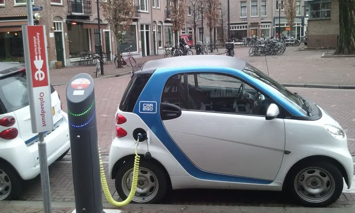 Voiture électrique réelle photographiée près d’une borne de recharge pour « Existe-t-il des bornes de recharge gratuites en Belgique? Où les trouver? »