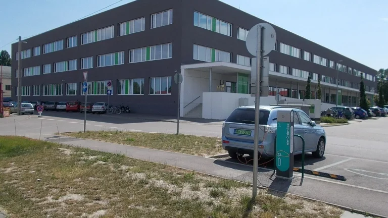 Voiture électrique réelle photographiée près d’une borne de recharge pour « Bornes de recharge publiques et privées en Belgique : Quel est le coût ? »
