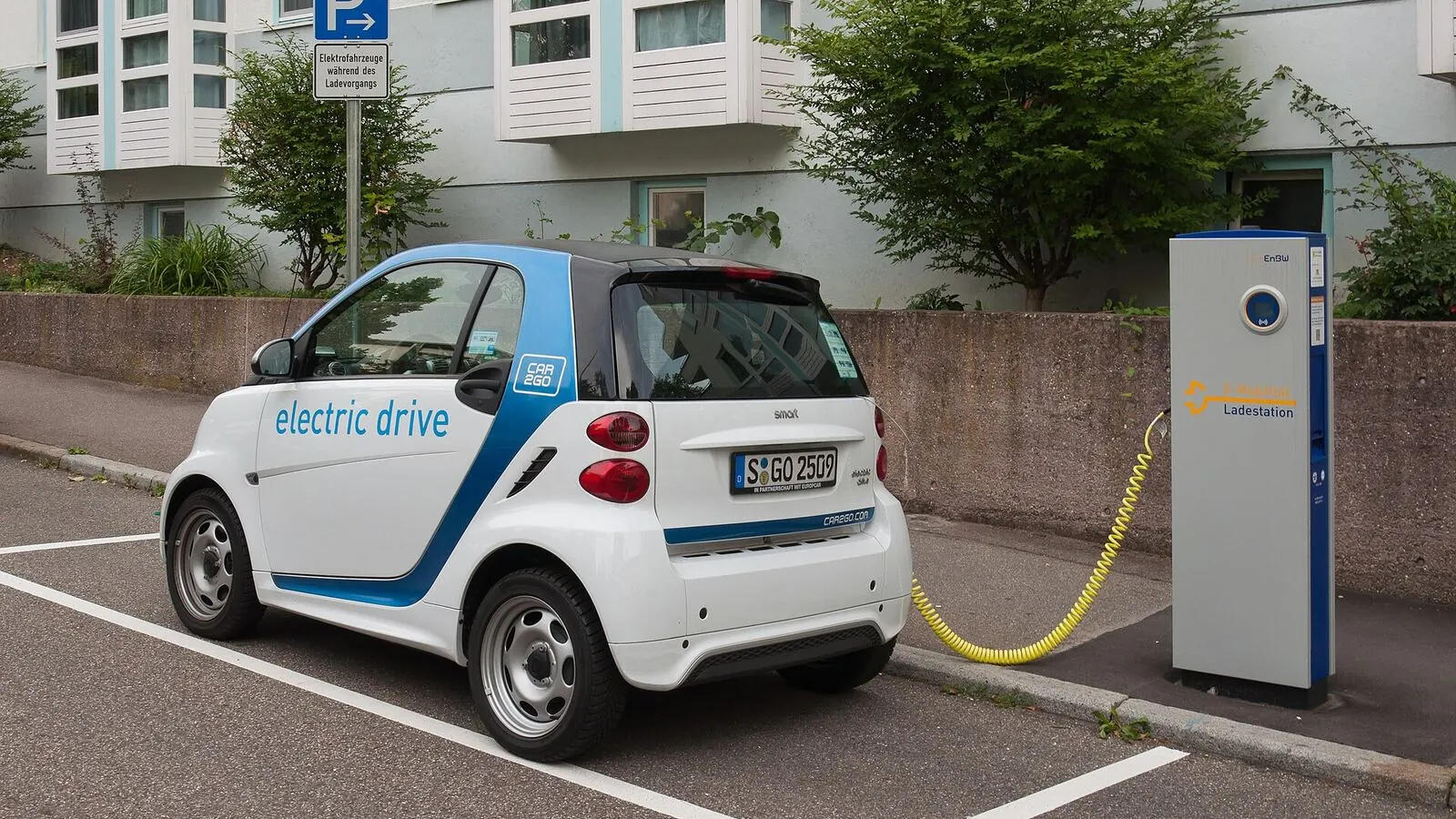 Voiture électrique réelle photographiée près d’une borne de recharge pour « Entretien et recharge climatisation voiture en Belgique »