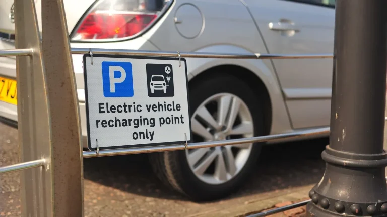 Voiture électrique réelle photographiée près d’une borne de recharge pour « Hybride rechargeable vs hybride simple : Lequel choisir en Belgique ? »
