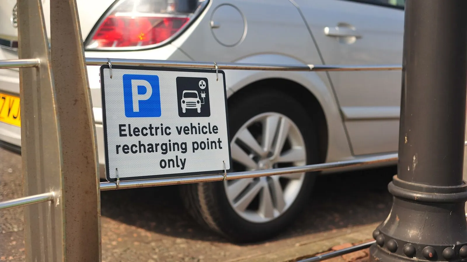 Voiture électrique réelle photographiée près d’une borne de recharge pour « Hybride rechargeable vs hybride simple : Lequel choisir en Belgique ? »