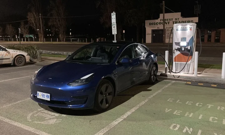 Voiture électrique réelle photographiée près d’une borne de recharge pour « Installer une borne de recharge en copropriété en Belgique: Droits et obligations »