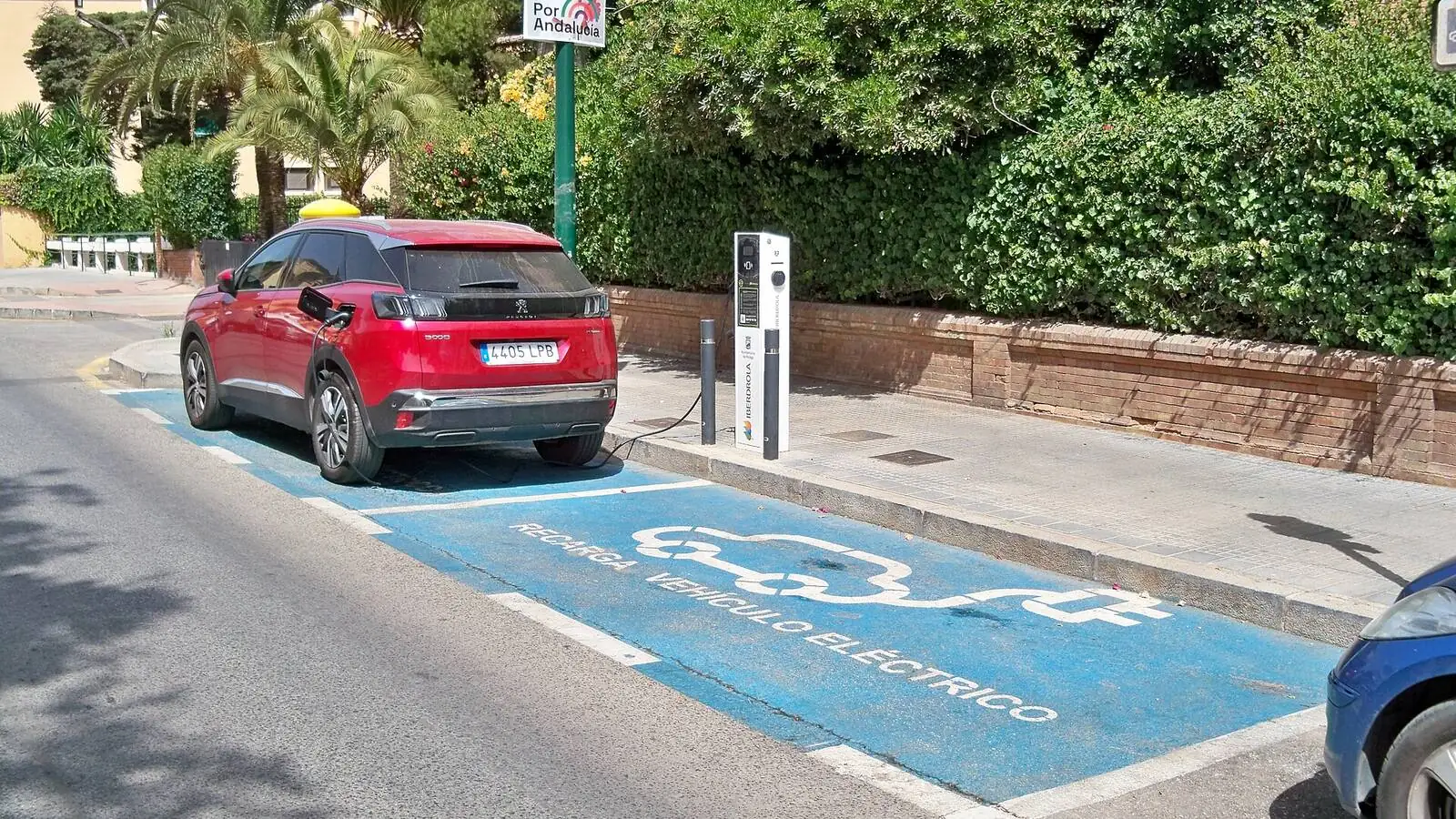 Voiture électrique réelle photographiée près d’une borne de recharge pour « Installer une borne de recharge à domicile en Belgique: Coût, aides et démarches »