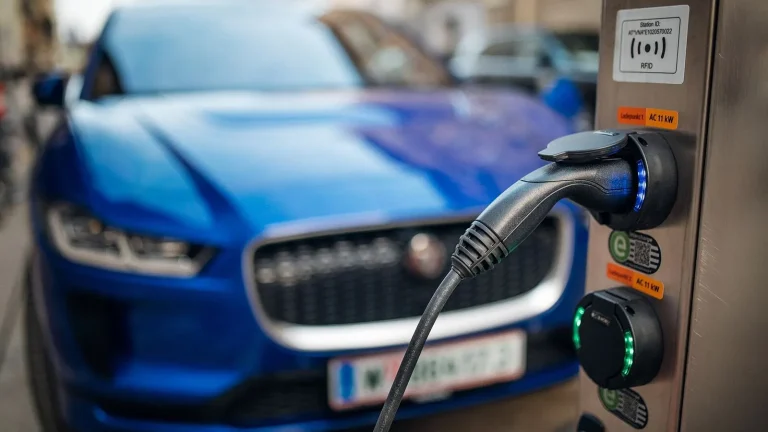 Voiture électrique réelle photographiée près d’une borne de recharge pour « Installer une Borne de Recharge à Domicile: Le Guide pour Propriétaires de VE d’Occasion »