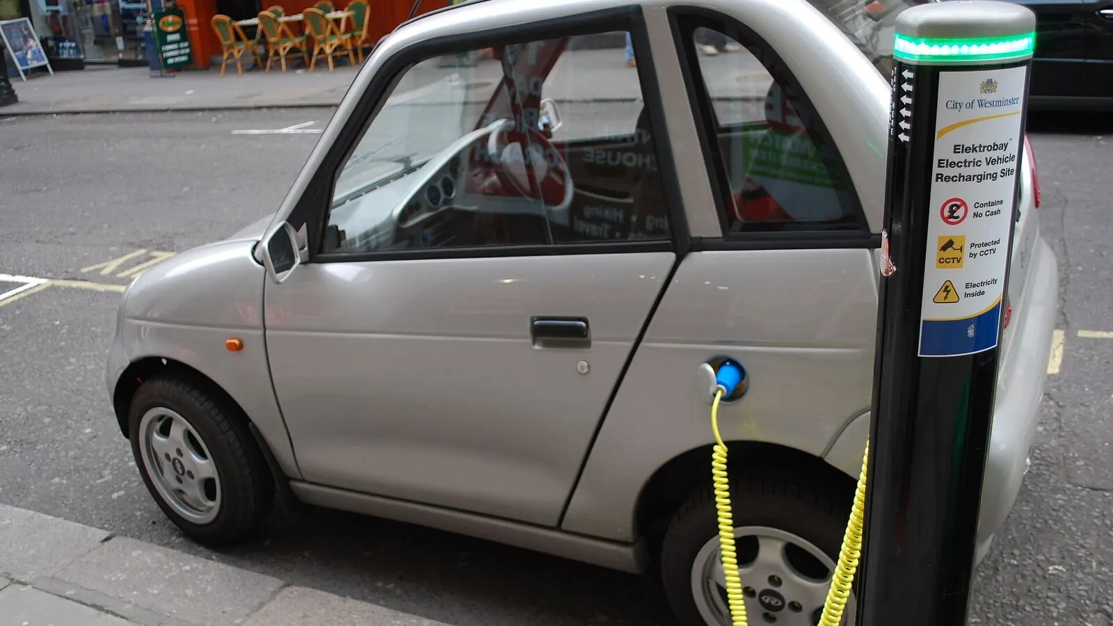 Voiture électrique réelle photographiée près d’une borne de recharge pour « Maximiser l’autonomie de sa VE en Belgique: Techniques de conduite et recharge »