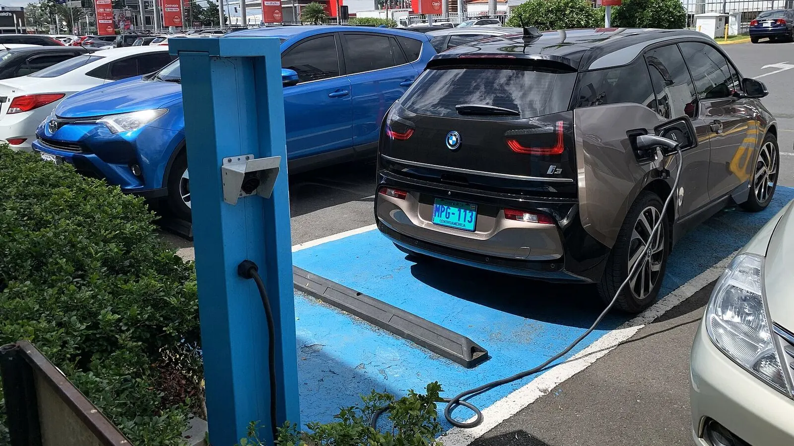 Voiture électrique réelle photographiée près d’une borne de recharge pour « Recharge AC vs DC en Belgique: Quelle différence pour ma voiture électrique? »