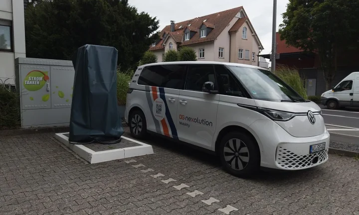 Voiture électrique réelle photographiée près d’une borne de recharge pour « Recharger en Conduisant ? Les Potentiels de la Recharge Dynamique pour l’Autonomie »
