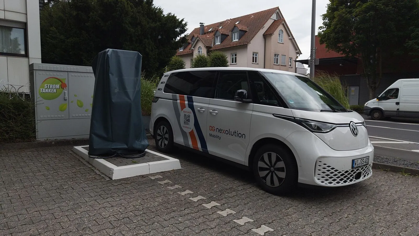 Voiture électrique réelle photographiée près d’une borne de recharge pour « Recharger en Conduisant ? Les Potentiels de la Recharge Dynamique pour l’Autonomie »