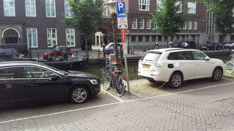 Voiture électrique réelle photographiée près d’une borne de recharge pour « Où recharger sa voiture électrique en Belgique ? Guide des bornes »