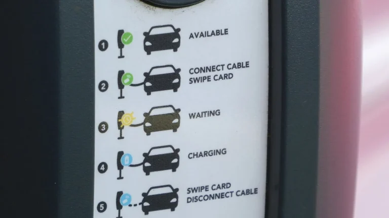 Voiture électrique réelle photographiée près d’une borne de recharge pour « Voitures Électriques Hybrides Rechargeables vs Pures Électriques en Belgique : Le Match »