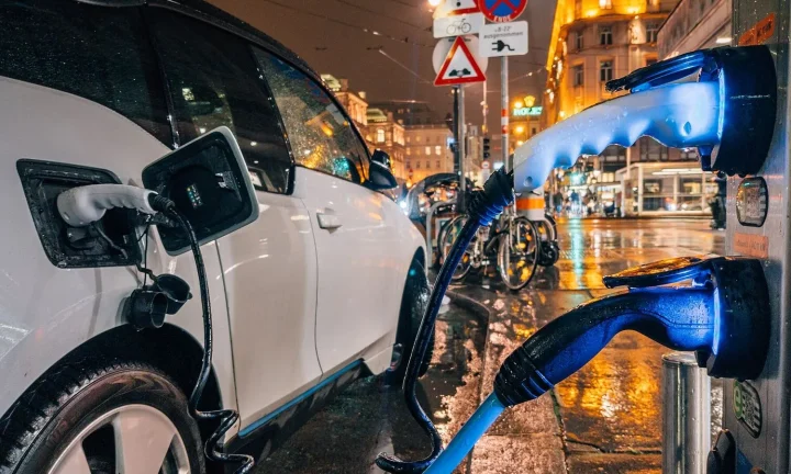 Voiture électrique réelle photographiée près d’une borne de recharge pour « Véhicule électrique versus hybride rechargeable : Comparatif pour la Belgique »