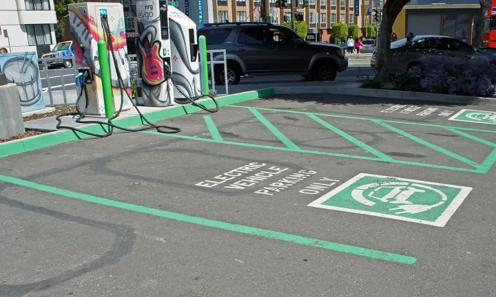 Voiture électrique réelle photographiée près d’une borne de recharge pour « Voyager en VE en Belgique : coût des recharges publiques et planification »