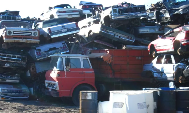 Voitures hors d’usage empilées avant leur traitement dans une installation de recyclage