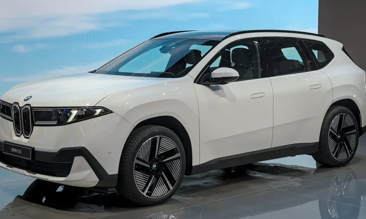 BMW iX3 blanc présenté sur un stand automobile
