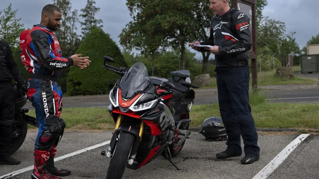 Deux motards vérifient une moto sportive rouge et noire lors d’une inspection de sécurité