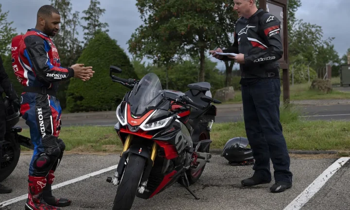 Deux motards vérifient une moto sportive rouge et noire lors d’une inspection de sécurité