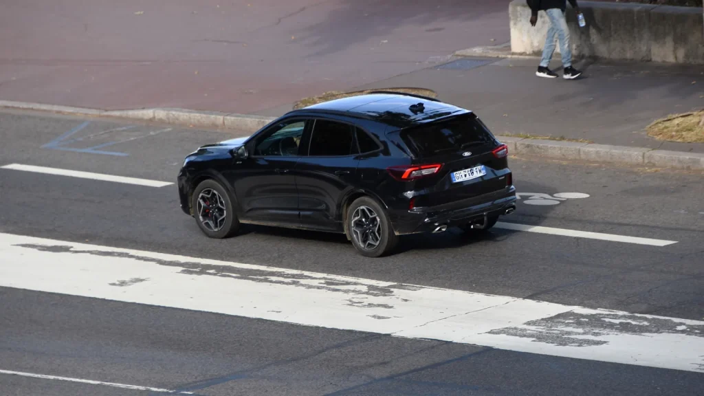 Ford Kuga PHEV noir 2024 circulant sur une route