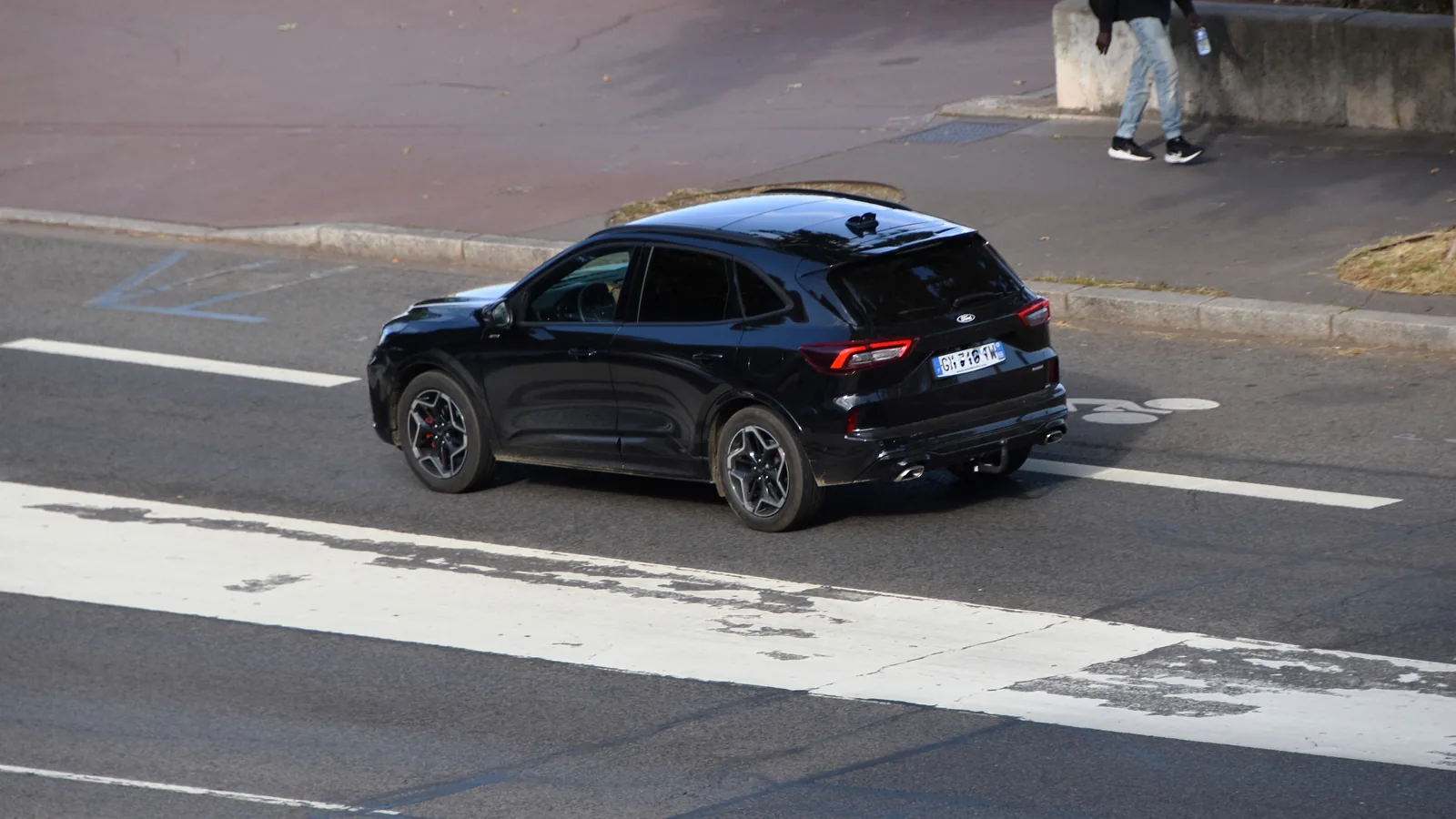 Ford Kuga PHEV noir 2024 circulant sur une route
