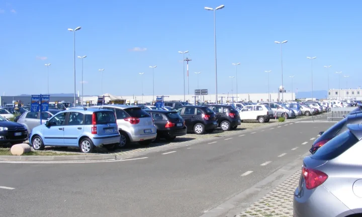 Rangées de voitures de location stationnées sur un parking près d’un aéroport