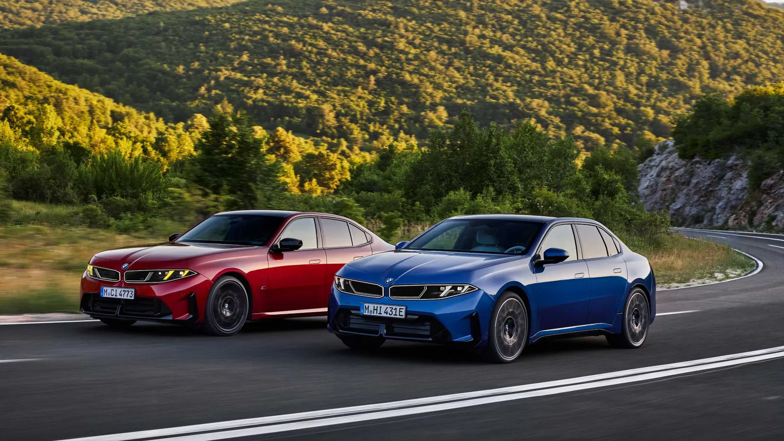 BMW Série 3 rouge et BMW i3 bleue roulant côte à côte
