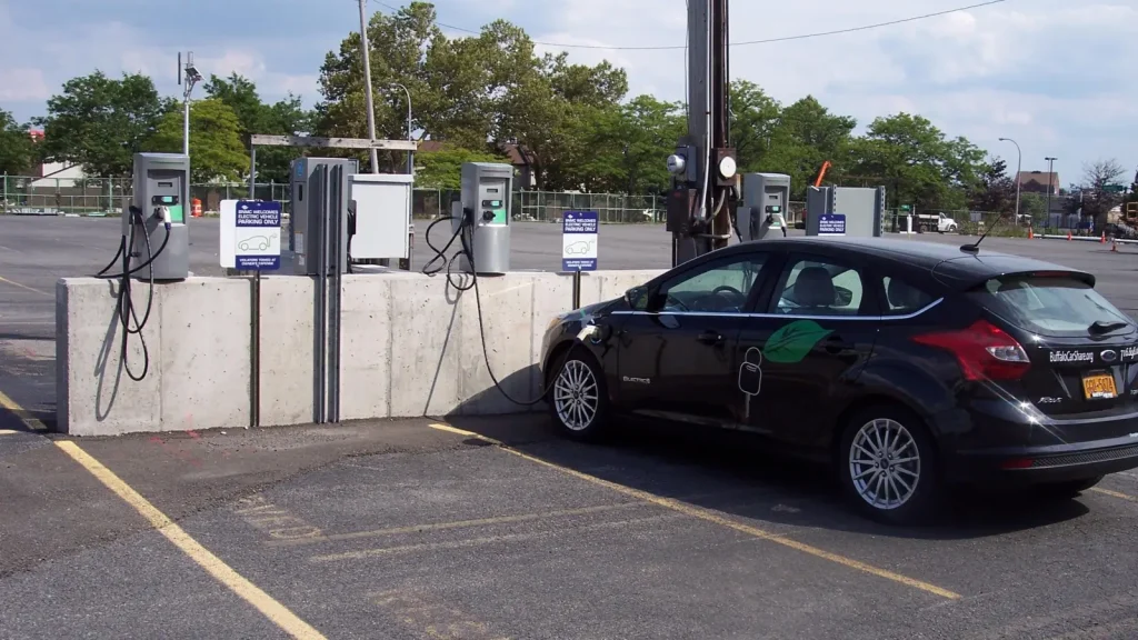 Voiture électrique branchée devant plusieurs bornes de recharge