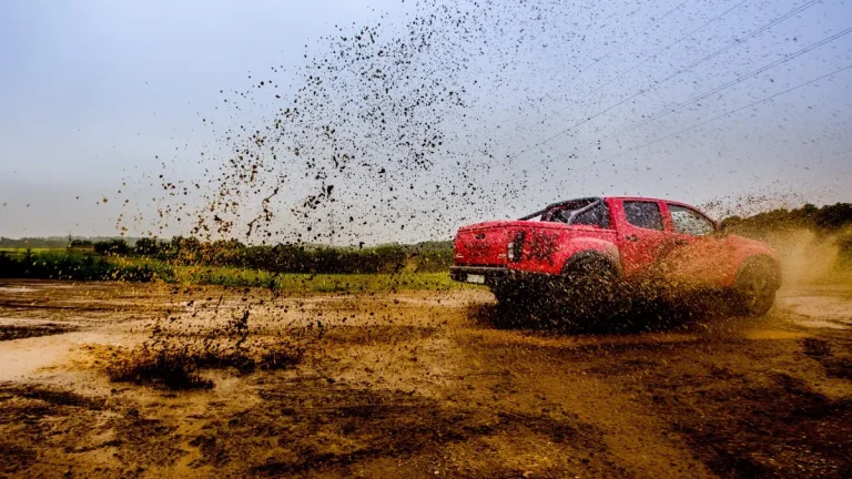 Voiture rouge roulant sur une piste boueuse à Andenne en Belgique