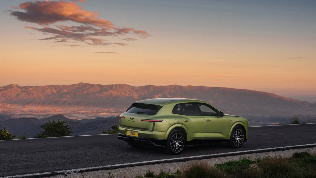 Bentley Torcal électrique vert stationné sur une route de montagne au coucher du soleil
