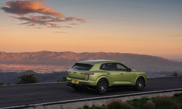 Bentley Torcal électrique vert stationné sur une route de montagne au coucher du soleil