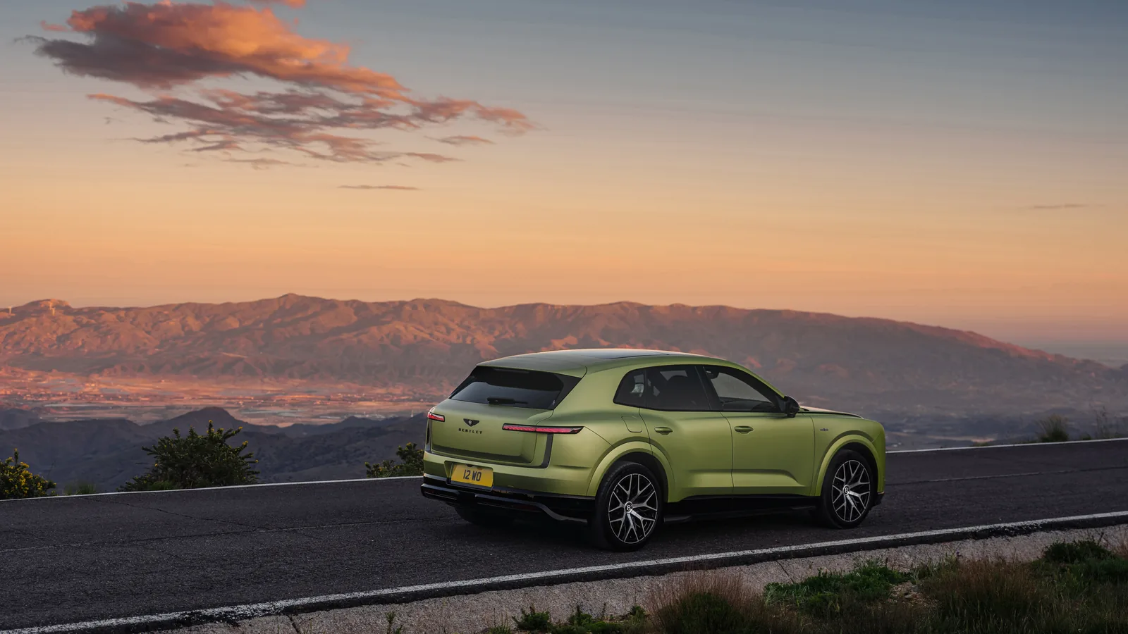 Bentley Torcal électrique vert stationné sur une route de montagne au coucher du soleil