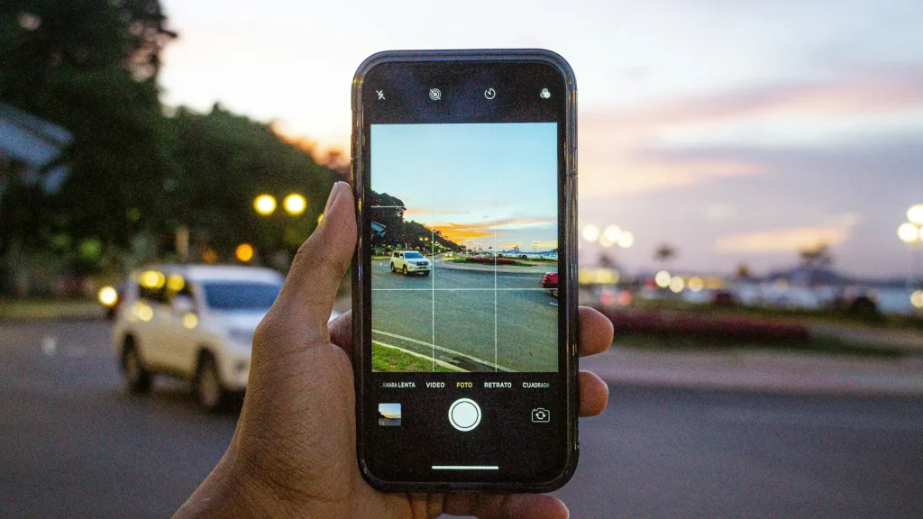 Personne photographiant une voiture avec un smartphone