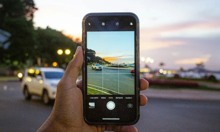 Personne photographiant une voiture avec un smartphone