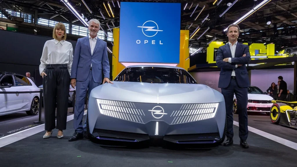 Opel STX Concept exposé au Mondial de Paris avec trois représentants de la marque
