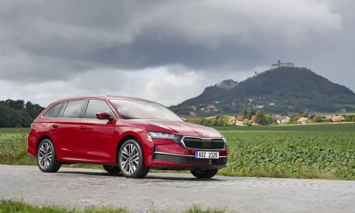 Škoda Octavia rouge photographiée devant un paysage de campagne